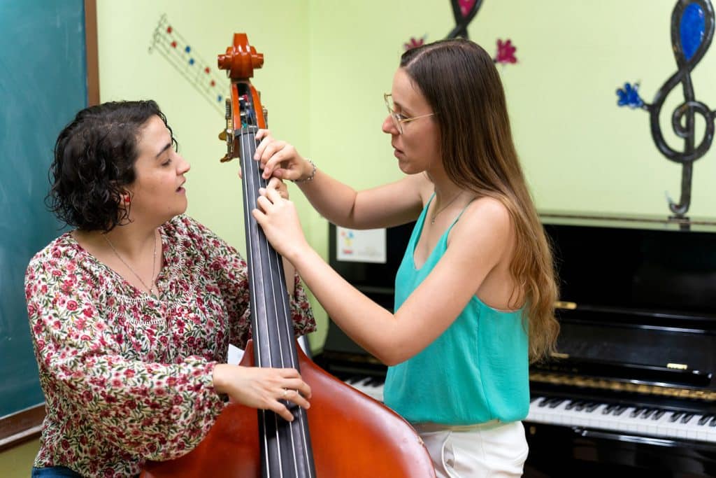 Double bass teacher helping a student during a double bass lesson in Balmain