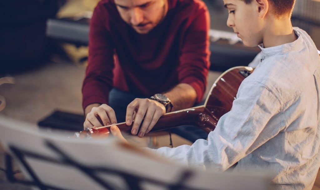 Child learning guitar with a music teacher at Inner West Institute of Music