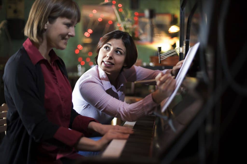 Piano teacher helping a student during a piano lesson in Sydney’s Inner West